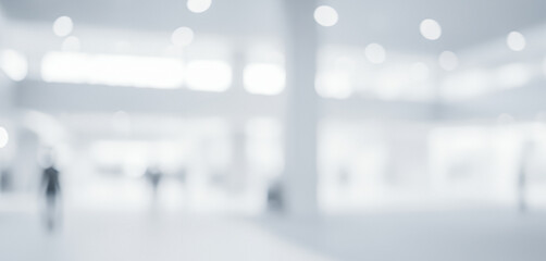 Bright abstract interior background with blurred human figures walking, creating a dynamic ambient scene with glowing soft light that feels modern and active across the space.