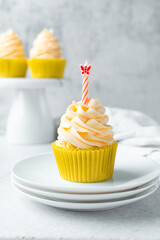 yellow cupcake with orange buttercream frosting on white background, tall buttercream frosting on yellow cupcakes