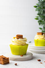 green cupcake with buttercream frosting and a sponge cake garnish on white background, tall buttercream frosting on green cupcakes