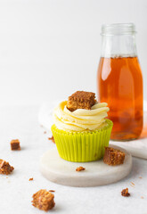green cupcake with buttercream frosting and a sponge cake garnish on white background, tall buttercream frosting on green cupcakes