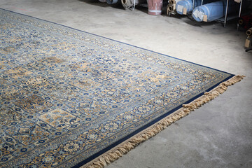 Overhead view of traditional Persian-style rug with blue and gold geometric pattern
