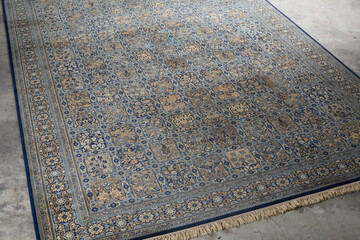 Overhead view of traditional Persian-style rug with blue and gold geometric pattern
