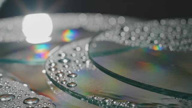 CDs and Droplets: A captivating macro shot reveals the reflective surface of several CDs, adorned with glistening water droplets and the play of light.