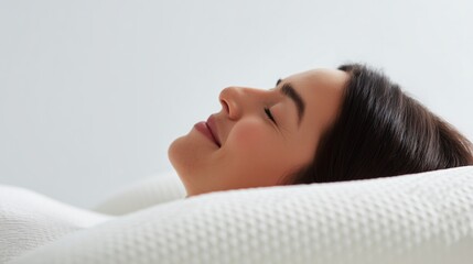 Woman resting comfortably with closed eyes on a textured white pillow