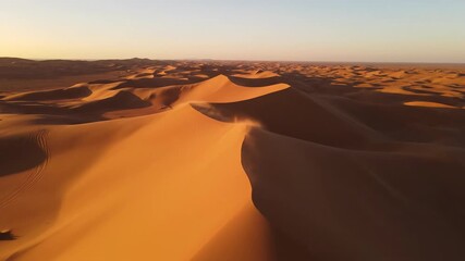Majestic aerial drone shot sweeping over vast, rippling desert sand dunes resembling a massive geological resonant wave formation adventure, pattern, blank canvas