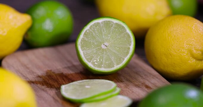 sliced juicy green lime lying on the table with yellow lemons , sliced ripe citrus fruits lime and large lemons are lying on a wooden table