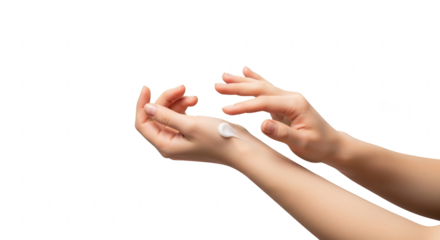 Close-up of female hands applying white moisturizing cream to delicate skin for care