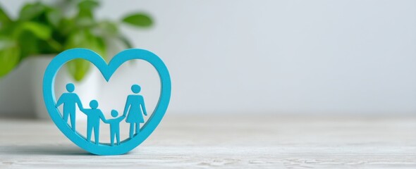 Warm family concept with blue heart frame containing silhouettes of parents and children on wooden background