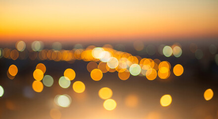 Dreamy sunset city skyline with warm glowing bokeh lights golden evening haze and soft urban silhouettes creating a tranquil atmospheric background for print web and social media
