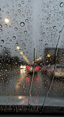 Blurred city lights visible through a car window covered in rain droplets