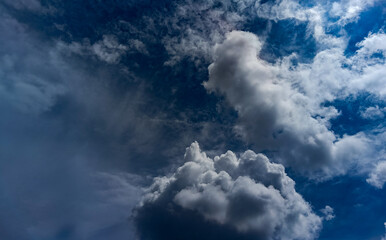 A dramatic deep-blue sky filled with textured clouds, creating a moody and atmospheric background ideal for design layouts, wallpapers, and visual creative projects.
