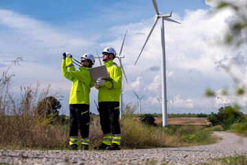 Workers conduct inspection at wind farm in clear weather while ensuring safety and efficiency in...