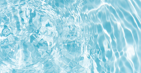 Blue water with ripples on the surface. Defocus blurred transparent blue colored clear calm water surface texture with splashes and bubbles. Water waves with shining pattern texture background.