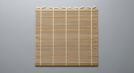 Traditional bamboo sushi rolling mat utensil on a minimalist gray background top view