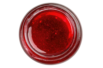 Close overhead view of a vibrant, clear red liquid in a glass jar