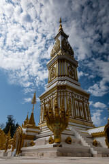Phra That Ming Mueang Maru Nakhon stupa with ornate gold carvings, Buddha statues, and naga...