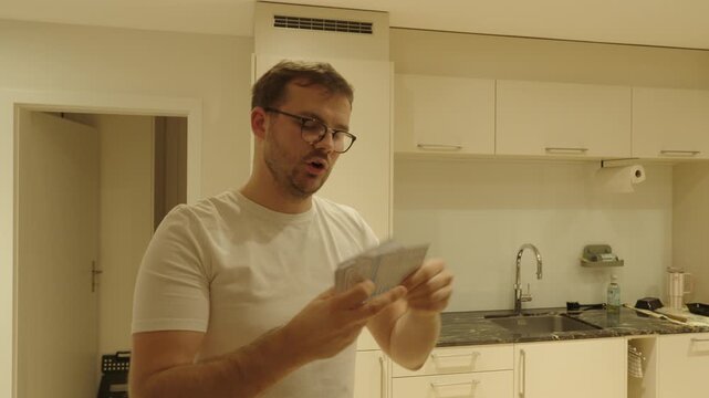 A man studies with flashcards in the kitchen &mdash; learning, repeating, and memorizing information for exams or self-improvement.