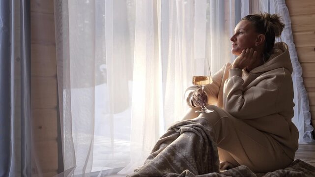 Calm woman enjoys peaceful winter moment wrapped in blanket near window Winter silence reflects mindful pause inner peace and soft light mood Deep connection with winter serenity and calm presence