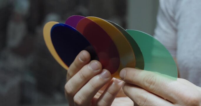 A person holding color samples for design or material selection, creative choice and palette concept.