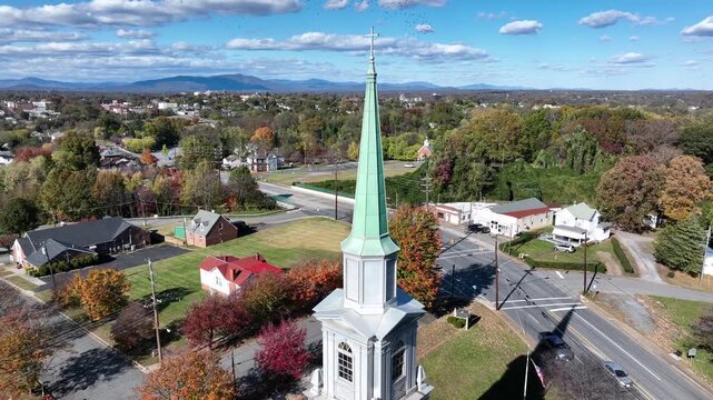 Aerial approacjing shot f church tower with driving cars on Main Street. Sunny day in small sitoric town of uSA. Lynchburg,Virginia in Autumn season. Wide shot.