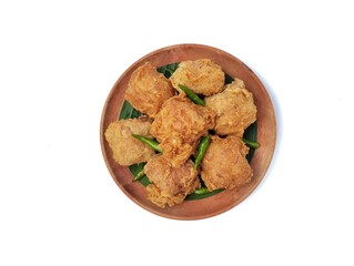 Gehu or Indonesian food made from fried tofu filled with bean sprouts and spices on wooden plate isolated on white background. Top view 