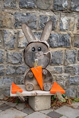 Wooden bunny and carrots against the stone wall