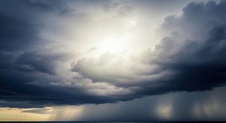 Dramatic stormy sky with sun breaking through dark clouds over the ocean