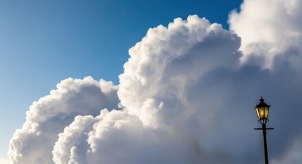 A solitary vintage street lamp glows warmly against a dramatic backdrop of massive billowing white clouds under a clear blue sky