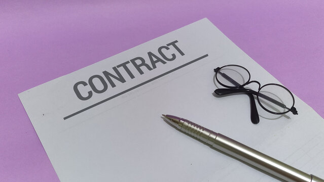 Business contract with glasses and pen on a purple background, ready for signing and approval
