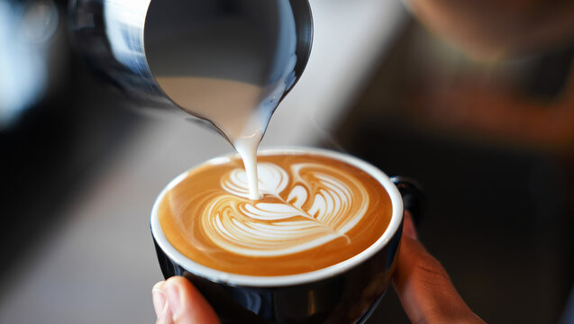 Pouring Frothy Milk into Espresso, Creating a Latte Art Masterpiece in a Black Ceramic Cup - Powered by Adobe