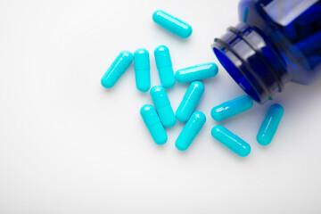 Health care background of pills and bottle on white surface flat lay