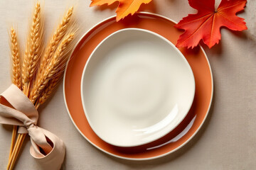 Autumn table setting with ceramic plates, wheat and orange leaves creating cozy seasonal atmosphere for fall dinner, harvest celebration and Thanksgiving gathering