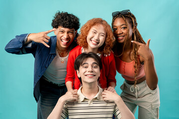 Portrait of diverse Generation Z friends posing on isolated blue screen.