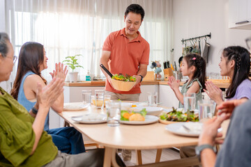 Asian loving family spending quality time, having dinner in cozy house. 