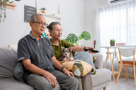 Asian senior mature couple watch movie together in living room at home. 