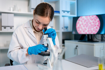 Caucasian female scientist in white lab coat working in the laboratory.