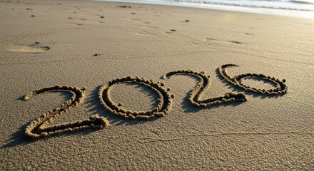 Golden 2026 year written in sand at sunset on tranquil beach, perfect for travel, new year, or vacation themes and celebrating new beginnings