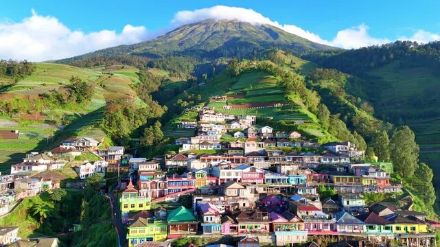 Drone video capturing a scenic hillside town with colorful houses and cultivated terraces in the mountains. Nepal Van Java Village, Mount Sumbing, Indonesia.