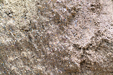 Detailed texture of sand mixed with small pebbles observed during a bright sunny day at a construction site