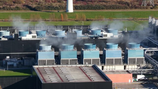 cooling fans hardware on top of the roof of a large scale data center in the Eemshaven, The Netherlands. Aerial drone close up video.