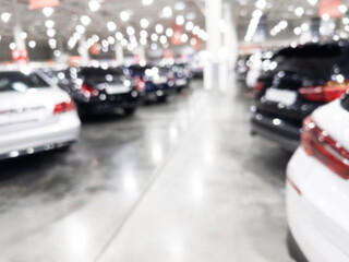 Blurred background with car dealership store interior. Blurred abstract dealership store with defocused cars. Blur bokeh transportation concept dealer showroom