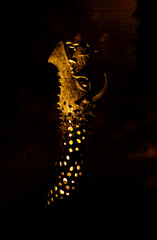 The fantasy creature statue features dark scales sharp spikes and a menacing open mouth illuminated from within