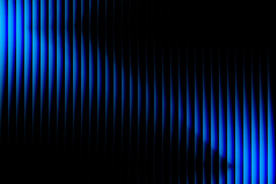 Abstract background with vertical blue light stripes creating a dynamic wave pattern against a deep black backdrop for modern design
