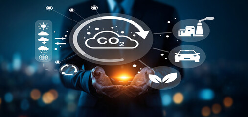 Businessman in Suit Holding Light Symbolizing Carbon Emission Reduction in Modern Urban Environment...