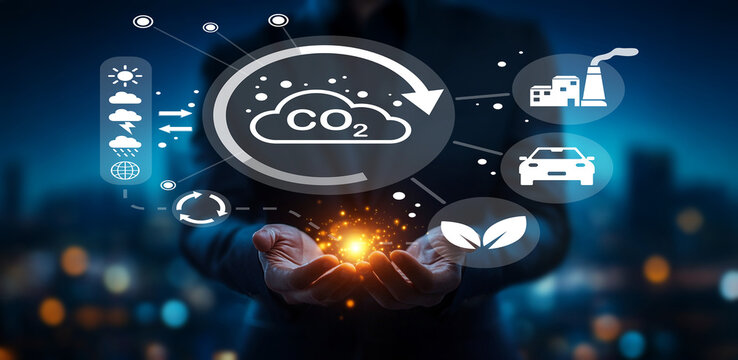 Businessman holding glowing sphere with digital environment icons representing carbon footprint, sustainability, technology, and eco-friendly initiatives at night