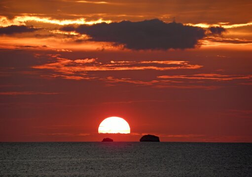  fiery sunset over the  pacific ocean  and catalinas islands from sugar beach resort at playa azucar cove, near playa flamingo, costa rica   