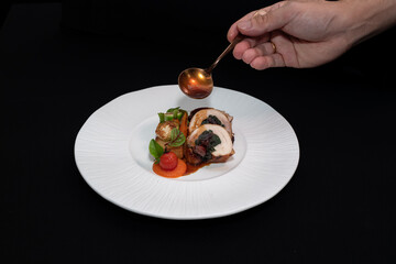 A culinary masterpiece on a plate with sauce being drizzled