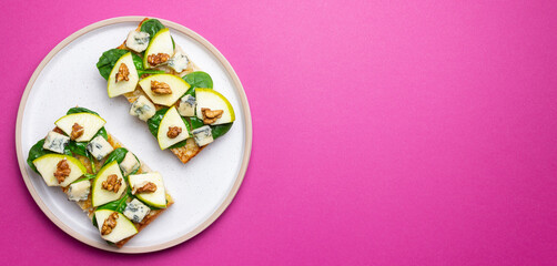Bruschetta with spinach, honey, blue cheese, pear, and nuts. Healthy eating. Vegetarian food.