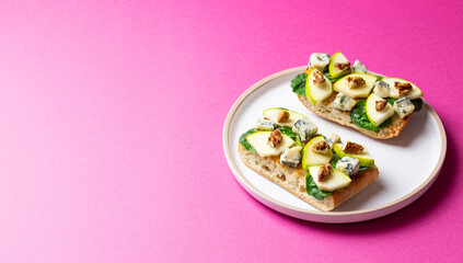 Bruschetta with spinach, honey, blue cheese, pear, and nuts. Healthy eating. Vegetarian food.