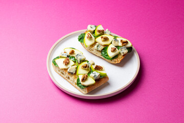 Bruschetta with spinach, honey, blue cheese, pear, and nuts. Healthy eating. Vegetarian food.